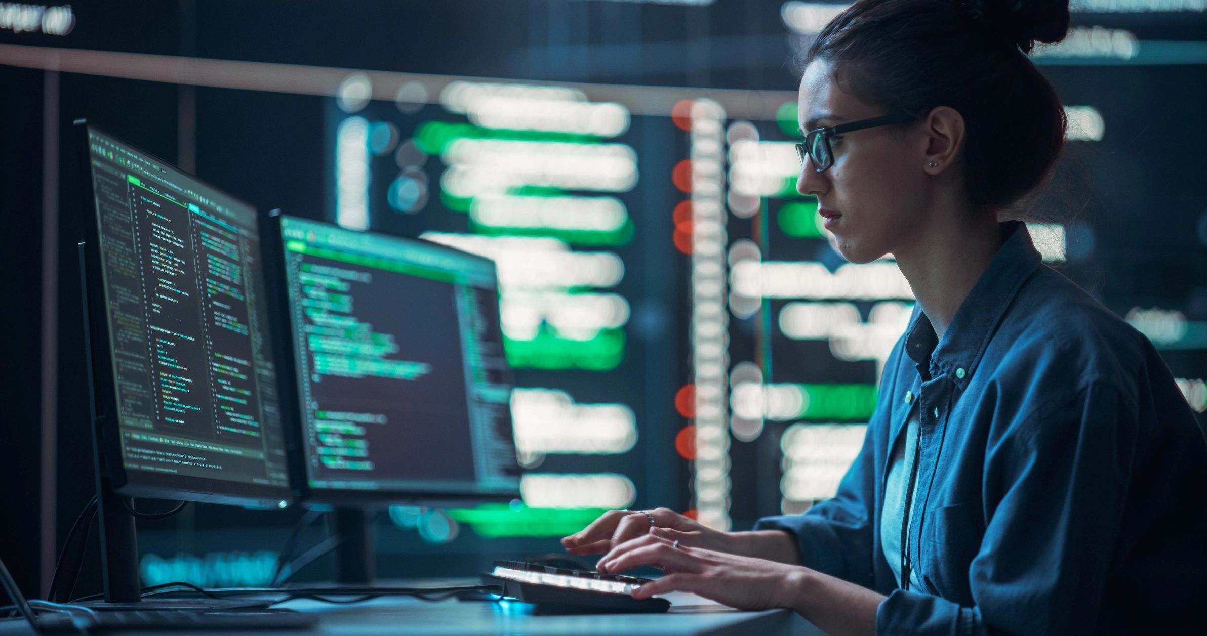 Developer working at a workstation with code on screens